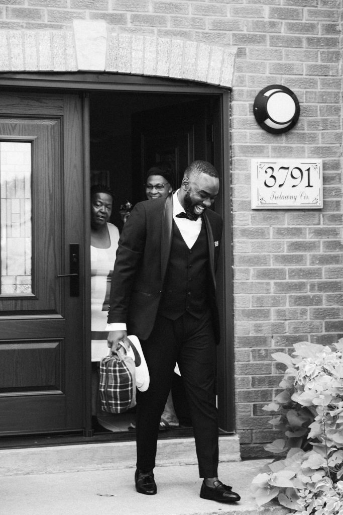 Groom smiling and leaving the house