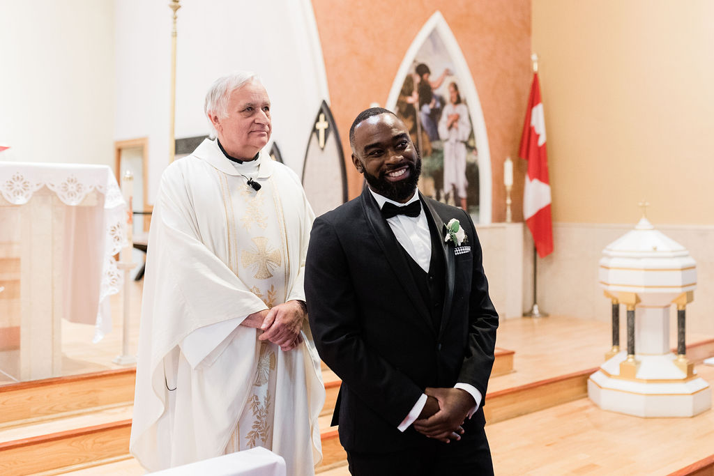 Groom smiling at the front of the church