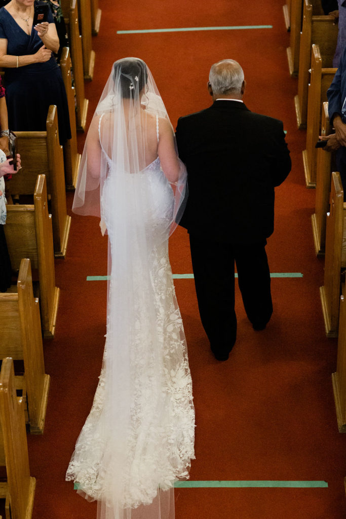 Bride being walked down the aisle by father, overhead shot