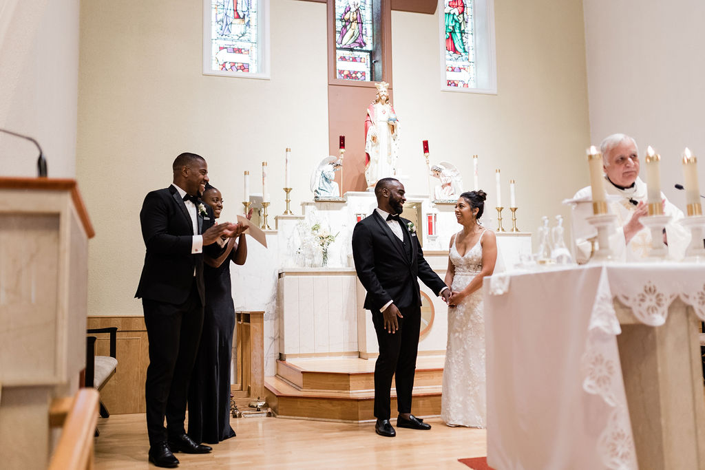 Bride and groom smiling behind altar after being married